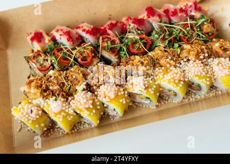 Das Konzept der Fast-Food-Lieferung nach Hause. Japanisches Essen, Nahaufnahme von saftigem frischem Sushi, verschiedene Sorten und Geschmäcker Stockfoto