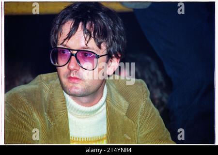 JARVIS COCKER, BACKSTAGE, 2000: Jarvis Cocker, der Leadsänger von Pulp, sitzende Nebenbühne, um den schlecht gezeichneten Jungen auf der NME-Bühne beim Reading Festival am 26. August 2000 zu sehen. Foto: Rob Watkins Stockfoto