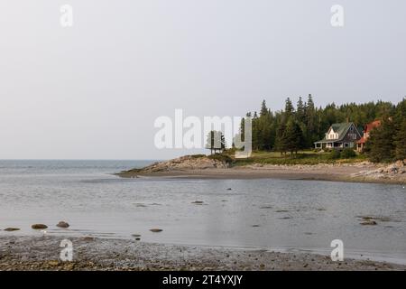 Zwei Häuser der Vorfahren in der Nähe des Strandes mit Blick auf die St. Lawrence River im Dorf Bic, Provinz Quebec, Kanada. Stockfoto