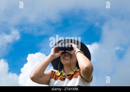 Junge Frau mit Fernglas auf dem Berg an einem sonnigen Tag. Frau, die beim Wandern ein Fernglas benutzt. Wanderfrau benutzt Ferngläser, um zu reisen und hat ein Stockfoto