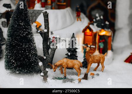 Weihnachtsfiguren von Hirschen und Weihnachtsbaum in der verschneiten Straße. Weihnachtsgeschenke und -Dekorationen. Stockfoto