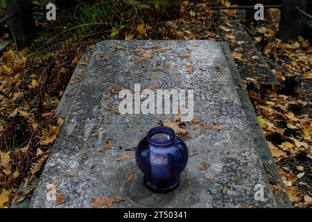 Warschau, Polen. November 2023. Auf einem alten Grabstein steht am Allerheiligen auf dem evangelisch-Augsburger Friedhof in Warschau eine Kerzenlampe. Allerheiligen (oder Dzie? Zaduszny (Polnisch) ist ein Feiertag in Polen. Es ist eine Gelegenheit, an verstorbene Verwandte zu erinnern. An diesem Tag bringen die Menschen Blumen, typischerweise Chrysanthemen, und Kerzen auf Friedhöfe. Der gesamte Friedhof ist voller Lichter in der Dunkelheit. Der Evangelisch-Augsburger Friedhof ist ein historischer lutherischer evangelischer Friedhof im Westen von Warschau. Seit seiner Eröffnung im Jahr 1792 haben mehr als 100.000 Menschen Bienen Stockfoto