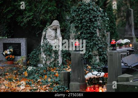 Alte Grabsteinskulpturen und Kerzen sind auf dem Friedhof am Allerheiligen auf dem Evangelisch-Augsburger Friedhof in Warschau zu sehen. Allerheiligen (oder Dzie? Zaduszny (Polnisch) ist ein Feiertag in Polen. Es ist eine Gelegenheit, an verstorbene Verwandte zu erinnern. An diesem Tag bringen die Menschen Blumen, typischerweise Chrysanthemen, und Kerzen auf Friedhöfe. Der gesamte Friedhof ist voller Lichter in der Dunkelheit. Der Evangelisch-Augsburger Friedhof ist ein historischer lutherischer evangelischer Friedhof im Westen von Warschau. Seit seiner Eröffnung im Jahr 1792 wurden dort mehr als 100.000 Menschen begraben. Stockfoto