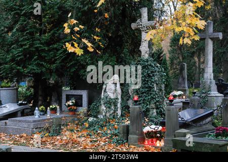 Warschau, Polen. November 2023. Alte Grabsteinskulpturen, Kreuze und Kerzen sind am Allerheiligen auf dem Friedhof evangelisch-Augsburg in Warschau zu sehen. Allerheiligen (oder Dzie? Zaduszny (Polnisch) ist ein Feiertag in Polen. Es ist eine Gelegenheit, an verstorbene Verwandte zu erinnern. An diesem Tag bringen die Menschen Blumen, typischerweise Chrysanthemen, und Kerzen auf Friedhöfe. Der gesamte Friedhof ist voller Lichter in der Dunkelheit. Der Evangelisch-Augsburger Friedhof ist ein historischer lutherischer evangelischer Friedhof im Westen von Warschau. Seit seiner Eröffnung im Jahr 1792 sind mehr t Stockfoto