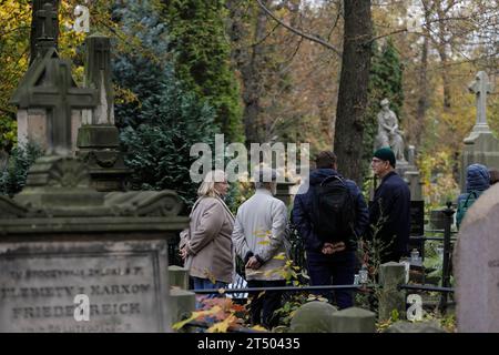 Warschau, Polen. November 2023. Am Allerheiligen-Tag auf dem evangelisch-Augsburger Friedhof in Warschau spazieren die Menschen durch den Friedhof. Allerheiligen (oder Dzie? Zaduszny (Polnisch) ist ein Feiertag in Polen. Es ist eine Gelegenheit, an verstorbene Verwandte zu erinnern. An diesem Tag bringen die Menschen Blumen, typischerweise Chrysanthemen, und Kerzen auf Friedhöfe. Der gesamte Friedhof ist voller Lichter in der Dunkelheit. Der Evangelisch-Augsburger Friedhof ist ein historischer lutherischer evangelischer Friedhof im Westen von Warschau. Seit seiner Eröffnung im Jahr 1792 sind mehr als 100.000 Menschen in buri ansässig Stockfoto