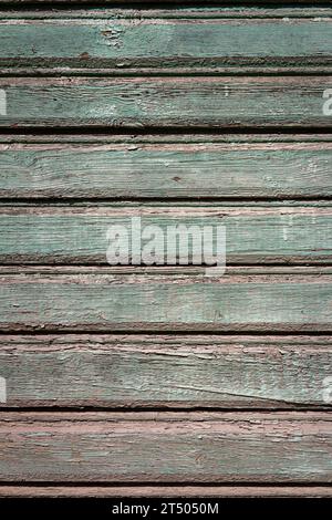 Abblätternde grüne Farbe auf verwittertem Holz. Abstrakter Architekturhintergrund Stockfoto