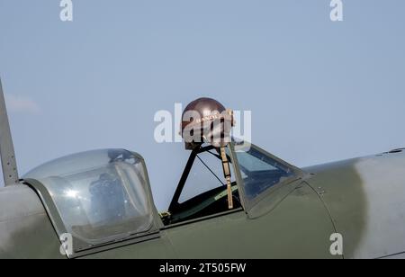 Ein Pilotenhelm hängt. Nahaufnahme eines Spitfire mit geöffnetem Cockpit Stockfoto