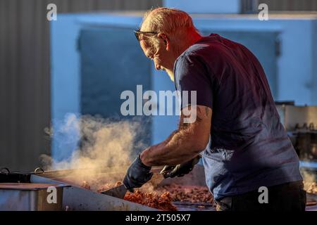 17. September 2023: Ein Mann kocht auf einem Grill Fleisch im Freien, um es zu verkaufen. Stockfoto