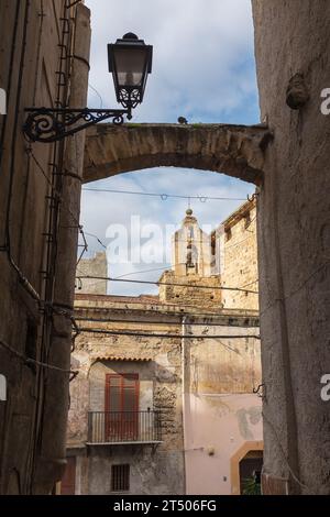 Palermo, Sizilien, 2016. Ein Vintage-Lampenpfosten in einer alten Gasse, der sich auf einen Kirchturm im Hintergrund öffnet (vertikal) Stockfoto