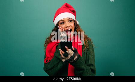 Schöne junge Frau bekommt gute Neuigkeiten zu Weihnachten, schockierte Aufregung, Studio Stockfoto