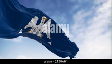 Die Flagge des Bundesstaates Louisiana winkt an einem klaren Tag. Mutter Pelikan in einem blauen Bereich mit dem Slogan des Staates. US-Bundesflagge. 3D-Darstellung. Flattern Stockfoto