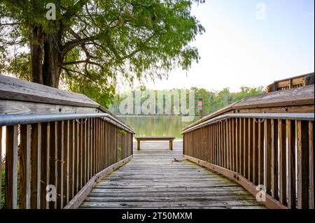 LAKE FAUSSE POINTE, LA, USA - 26. OKTOBER 2023: Hölzerne Rampe und Dock zwischen zwei Hütten mit Blick auf das Wasser im Lake Fausse Pointe State Park Stockfoto