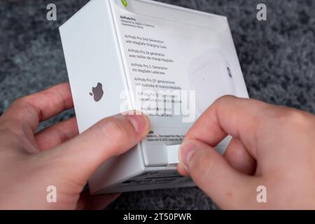 Jurmala, Lettland - 21 09 2023: Das neue Apple-Gadget wird entpackt. Frau reißt mit neuen Kopfhörern – AirPods Pro 2 Generation – einen Schutzstreifen in einer Box ab. Stockfoto