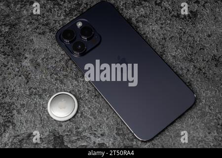 Jurmala, Lettland - 21 09 2023: Auf dem Tisch Silber AirTag Apple und iphone. Air Tag Gadget, um deine Sachen und dein Geld zu verfolgen. Stockfoto