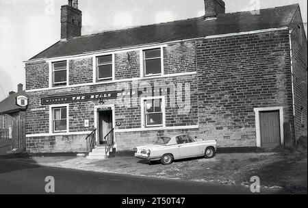 1960er Jahre, ein historischer Wagen von Triumph Herald, der vor dem Bulls Head, einem Pub der Wilson's Brewery, an der Ripponden Rd, Oldham, England, Großbritannien, geparkt wurde. Sie wurde 2015 geschlossen. Stockfoto