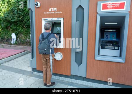 Istanbul, die Türkei, Ein Mann, der Geld an einem geldautomaten auf der Straße übertränkt. Nur redaktionell. Stockfoto