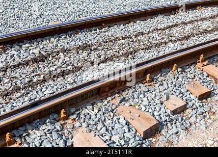 Verlegung neuer Straßenbahnschienen auf Holzschwellen. Instandsetzung von Eisenbahngleisen und Straßenbahnlinien. Konzeptfoto von Straßenreparaturen Stockfoto