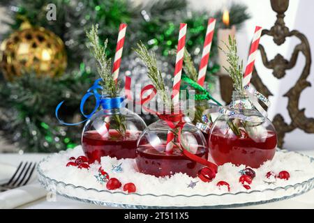 Gin mit Tonic und Preiselbeersaft. Der Cocktail ist voller festlicher Weihnachtsaromen. Serviert in transparenten Schüsseln mit einem Zweig Rosmarin. Stockfoto