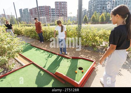 Kinder spielen Golf auf dem Spielplatz, Kunstrasen, Aktivitätsspiel für Kinder Stockfoto