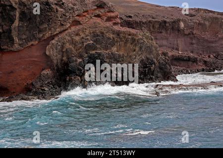 Wellen schlagen gegen die bunten Klippen von Las Coloradas auf Lanzarote. Vom März 2023 Stockfoto