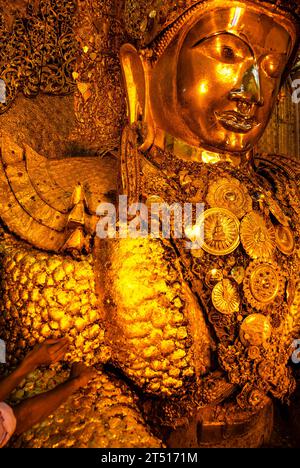 Die Menschen kleben goldene Blätter auf die goldene Mahamuni Buddha Statue, Mahamuni Paya Pagode, Mandalay, Myanmar, Asien Stockfoto