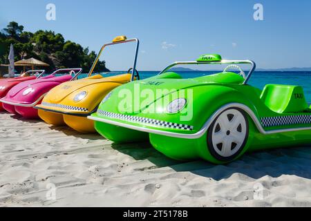 Treten Sie Katamarane in Form eines Fahrzeugs in einer Reihe. Boote in verschiedenen Farben stehen auf Sand Stockfoto