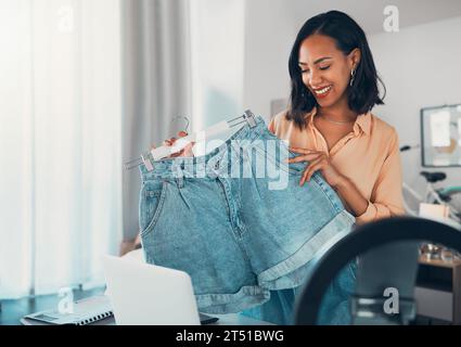 Fashion influencer, style and design with a creative and trendy female holding denim shorts in her small business and startup vlog. Fashionable Stockfoto
