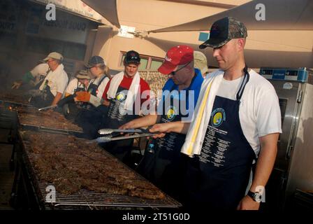 1007047660S-091 MANAMA, Bahrain (4. Juli 2010) Freiwillige von Cooks from the Valley, einer kalifornischen Freiwilligengruppe, grillen Steaks für eine Feier am 4. Juli bei der Naval Support Activity Bahrain. Die Gruppe brachte 26 Köche und mehr als 5.000 Steaks nach Bahrain, um ihre Unterstützung für AmericaХs Männer und Frauen in Uniform und ihre Familien zu zeigen. Marineblau Stockfoto