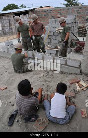 110517ET173-200 LA TAVESIA, Ecuador (17. Mai 2011) ecuadorianische Jungen beobachten, wie Seabees, die dem Naval Mobile Construction Battalion (NMCB) 28 zugewiesen sind, und Marines, die dem 8. Ingenieur-Support-Bataillon zugewiesen sind, während eines fortlaufenden Promise 2011 Gemeindedienstes eine Mauer an ihrer Schule in La Tavesia, Ecuador, errichten. Weiterhin versprechen wir eine fünfmonatige humanitäre Hilfsmission in der Karibik, in Mittel- und Südamerika. (U.S. Air Force Stockfoto