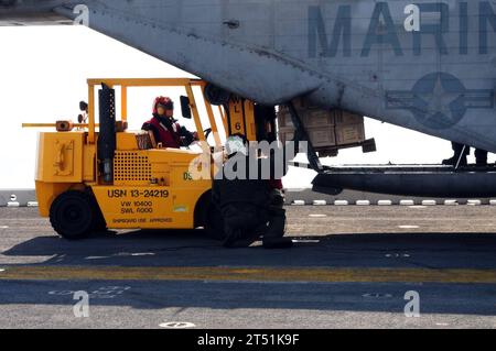 1001167508R-031 ATLANTISCHER OZEAN (16. Januar 2010) Seeleute an Bord des amphibischen Mehrzweck-Angriffsschiffs USS Bataan (LHD 5) beladen nach ihrer Ankunft von Morehead City, N.C. mehr als 1.300 Marines, die der 22. Marine Expeditionary Unit (22. MEU) zugewiesen sind, an Bord von Bataan in Morehead City, um die Operation Unified Response zu unterstützen. Bataan ist unterwegs nach Haiti, um humanitäre Hilfe und Katastrophenhilfe nach einem Erdbeben der Stärke 7,0 am 12. Januar 2010 zu leisten. Marineblau Stockfoto