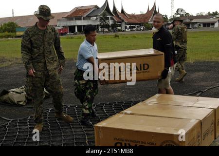 0910124917P-059 PADANG, Indonesien (12. Oktober 2009) Marines, die dem Combat Logistics Battalion (CLB) 31 der 31st Marine Expeditionary Unit (31st MEU) zugewiesen sind, indonesische Dienstmitglieder und Mitarbeiter des Roten Kreuzes laden ein Frachtnetz mit Vorräten der United States Agency for International Development (USAID). Die Vorräte werden mit CH-53E Super Hallion Helikoptern der Marine Medium Helicopter Squadron (HMM) 265 (verstärkt) in entlegene Gebiete von West Sumatra, Indonesien, transportiert. Die 7. US-Flotte koordiniert die US-Militärhilfe für die Opfer der jüngsten Erdbeben im Westen Stockfoto