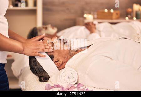 Gesundheit, Gesichtsmassage und Senior Mann in einem Spa für Wellness, Selbstpflege und Zen-Behandlung. Entspannen Sie sich, beruhigen Sie sich und Masseurinnen Hände, die Schönheitsgesicht Routine machen Stockfoto