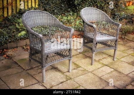 Gartenecke. Sessel in einem Entspannungsgarten im Hinterhof eines Hauses. Dekorative Gartenmöbel oder Stühle in der Nähe von Zierpflanzen Stockfoto