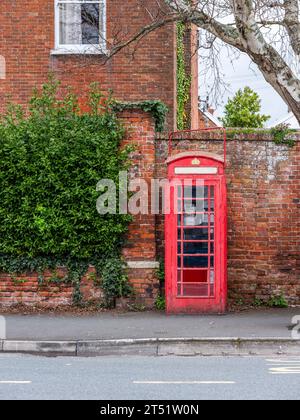 Eine rote britische/englische Telefonbox in einem Dorf. Stockfoto