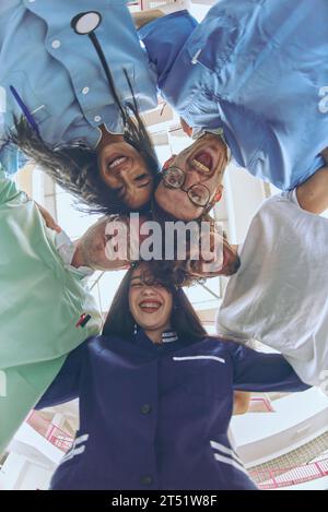 Gruppe von Ärzten eine medizinische Krankenschwester und ein Chirurg werden in einer herzlichen Umarmung gefangen und zeigen ihre Einheit, Teamarbeit und tiefe Verbindung in der Stockfoto