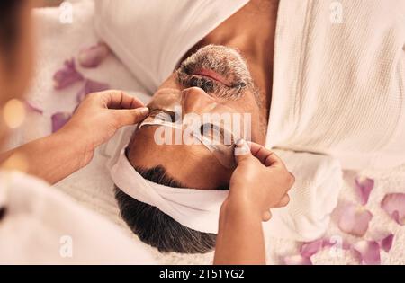 Wellness, Augenmaske und reifer Mann in einem Spa für Gesundheit, Selbstpflege und Zen-Behandlung. Entspannen Sie sich, beruhigen Sie sich, und Masseurin Hände einer Schönheitsmassage Stockfoto