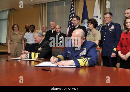 0904018273J-014 WASHINGTON (1. April 2009) Chief of Naval Operations (CNO) ADM. Gary Roughead links und Commandant of the Coast Guard ADM. Thad W. Allen unterzeichnen während einer Unterzeichnungszeremonie im Pentagon eine Vereinbarung für das Safe Harbor-Programm. Das Abkommen spiegelt die Verpflichtung der Marine und der Küstenwache wider, schwer verletzten, kranken oder verletzten Mitgliedern des Dienstes und ihren Familien eine lebenslange individuelle, koordinierte, nichtmedizinische Versorgung zu bieten. Marineblau Stockfoto