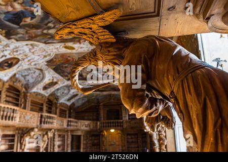 Geschnitzte, lebensgroße Holzfigur des Künstlers Karl Stilp in der Bibliothek des Klosters Waldsassen. Regale und Schnitzereien in der Klosterbibliothek Waldsassen sind aus Lindenholz gefertigt. Waldsassen, Deutschland Stockfoto