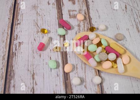 Verschiedene pharmazeutische Arzneimittel-Pillen, Tabletten und Kapseln auf Holzlöffel. Stockfoto