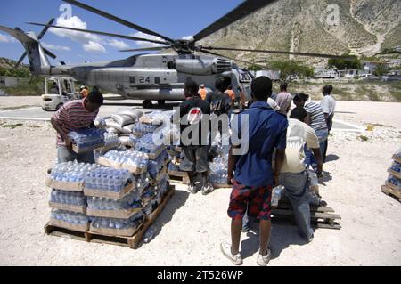 0809229620B-004 GONAIVES, Haiti (22. September 2008) Haitianische Hilfskräfte helfen Mitgliedern des US-Militärs und der Vereinten Nationen, die an Bord des amphibischen Angriffsschiffs USS Kearsarge (LHD 3) gehen, Nahrung und Wasser zu entladen, um den von den jüngsten Hurrikanen in Haiti betroffenen Menschen zu helfen. Kearsarge hat US-Soldaten aus allen militärischen Zweigen und eine multinationale Gruppe von medizinischem und unterstützendem Personal an Bord genommen. Marineblau Stockfoto
