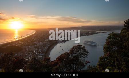 Das Kreuzfahrtschiff erreicht den Hafen von Tauranga bei Sonnenaufgang, vom Gipfel des Mount Maunganui aus gesehen Stockfoto