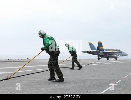 0905304015L-007 PACIFIC OCEAN (30. Mai 2009) Seeleute, die der Abteilung Air zugewiesen sind, Division V-2 an Bord des Flugzeugträgers USS George Washington (CVN 73) führen Sie ein einziehendes Fanggerät in seine eingestellte Position, nachdem eine F/A-18C Hornet, die den „Goldenen Drachen“ der Strike Fighter Squadron (VFA) 192 zugeordnet ist, eine verhaftete Landung macht. George Washington, der einzige ständig vorgesetzte Flugzeugträger der Navy, führt derzeit eine Bewertung der Effizienz der Kampfoperationen im westlichen Pazifik durch. Marineblau Stockfoto