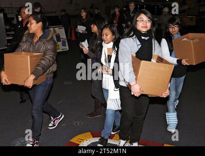 0912163418M-014 YOKOSUKA, Japan (16. Dezember 2009) Freiwillige des amerikanischen Roten Kreuzes tragen Boxen mit Weihnachtskarten, die aus aller Welt für Seeleute an Bord des Flugzeugträgers USS George Washington (CVN73) der Nimitz-Klasse gespendet wurden. Die Freiwilligen gaben die Karten an Seeleute aus, als sie das Schiff verließen, um in die Freiheit zu gehen. George Washington, der einzige ständig vorgelagerte Flugzeugträger der NavyХs, bereitet sich auf seine geplante selektive begrenzte Verfügbarkeit vor. Marineblau Stockfoto