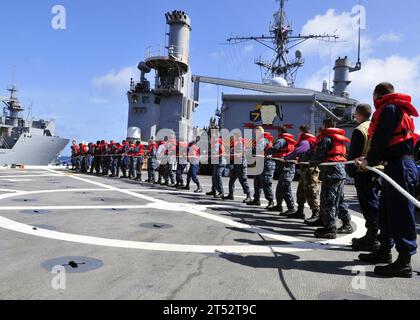 110408ZF681-088 PAZIFISCHER OZEAN (8. April 2011) Seeleute an Bord des amphibischen Transportdockschiffs USS Cleveland (LPD 7) steuern eine Linie während einer Auffüllung auf See mit dem militärischen Sealift Command Lewis und dem Clark-Klasse Trockenfracht- und Munitionsschiff USNS Charles Drew (T-AKE 10). Marineblau Stockfoto