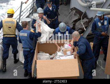 1002097088A-110 GULF OF ADEN (9. Februar 2010) Seeleute, die an Bord des Arleigh-Burke-Klasse-Raketenzerstörers USS Farragut (DDG 99) stationiert sind, entpacken während einer Auffüllung eine Palette von Post. Farragut ist Teil der Combined Task Force 151, einer multinationalen Task Force zur Durchführung von Anti-Piraterie-Operationen im Golf von Aden. Stockfoto