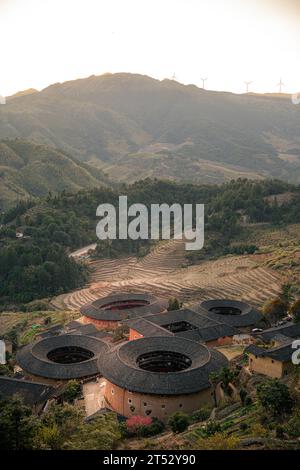 Aus der Nähe von Tulou, den einzigartigen Wohnungen von Hakka in Fujian, China. Tianluokeng Tulou Cluster, vertikales Sonnenuntergangsbild mit Kopierraum für Tex Stockfoto