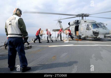 1103258288P-244 PAZIFISCHER OZEAN (25. März 2011) Seeleute an Bord des Lenkraketenzerstörers USS Fitzgerald (DDG 62) der Arleigh-Burke-Klasse laden Kisten mit humanitären Hilfsgütern auf einen Helikopter SH-60 Sea Hawk. Fitzgerald, das Flaggschiff der Zerstörergeschwader (DESRON) 15, befindet sich auf See östlich der Präfektur Miyagi in Japan, um Katastrophenhilfe und humanitäre Hilfe zu leisten, wie sie zur Unterstützung der Operation Tomodachi vorgesehen sind. Stockfoto