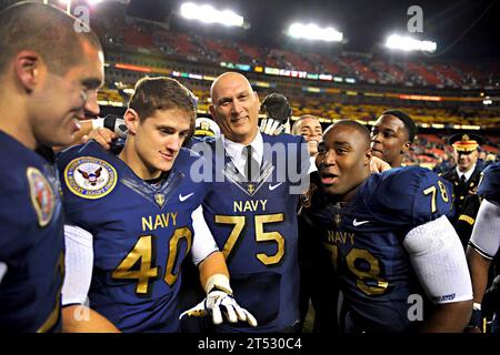 111210AO884-420 LANDOVER, MD. (10. Dezember 2011) Generalstabschef der US-Armee, General Raymond T. Odierno, trägt ein Navy-Football-Trikot und posiert für ein Foto mit Navy Midshipmen, nachdem er während des Spiels des 112. US Army vs. U.S. Navy College gegen Navy 27:21 verloren hatte. In diesem Jahr wurde das Spiel zum ersten Mal auf dem FedEx Field in Landover, MD, ausgetragen. (US-Armee Stockfoto