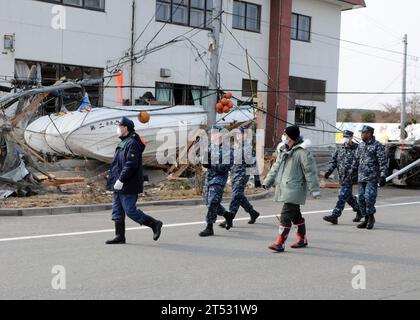 110314MU720-041 MISAWA, Japan (14. März 2011)Masayoshi Sawaguchi, Direktor der Abteilung für Politik und Finanzen der Stadt Misawa, führt die Seeleute, die der Marineflugfazilität Misawa zugewiesen sind, in ein Gebiet am Misawa-Fischereihafen, in dem sie aufgeräumt werden müssen. Mehr als 90 Seeleute der Naval Air Facility Misawa meldeten sich freiwillig, um Mitarbeitern und Mitgliedern der Gemeinde Misawa bei der Reinigung nach einem Erdbeben und Tsunami zu helfen. Stockfoto