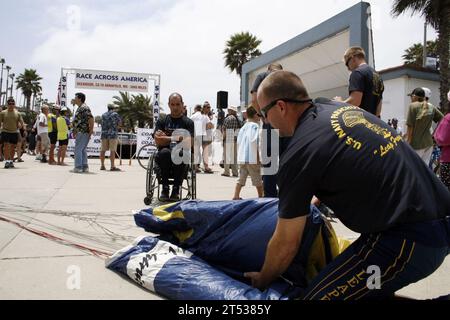 0906177603L-108 OCEANSIDE, Kalif. (17. Juni 2009) Jim Woods, ein pensionierter Navy SEAL, der dem US Navy Parachute Team, den Leap Frogs, zugeteilt wurde, spricht mit dem Zuschauer Carlos Moleda, während er nach einer Fallschirmdemonstration seinen Fallschirm packt, um den Start des Race Across America Marathon, einem 3.000 km langen Radrennen, zu markieren. Die Leap Frogs sind in San Diego beheimatet und treten an verschiedenen Orten im ganzen Land auf, um die Exzellenz der Marine zu demonstrieren und das Bewusstsein für die Marine Special Warfare zu schärfen. Stockfoto